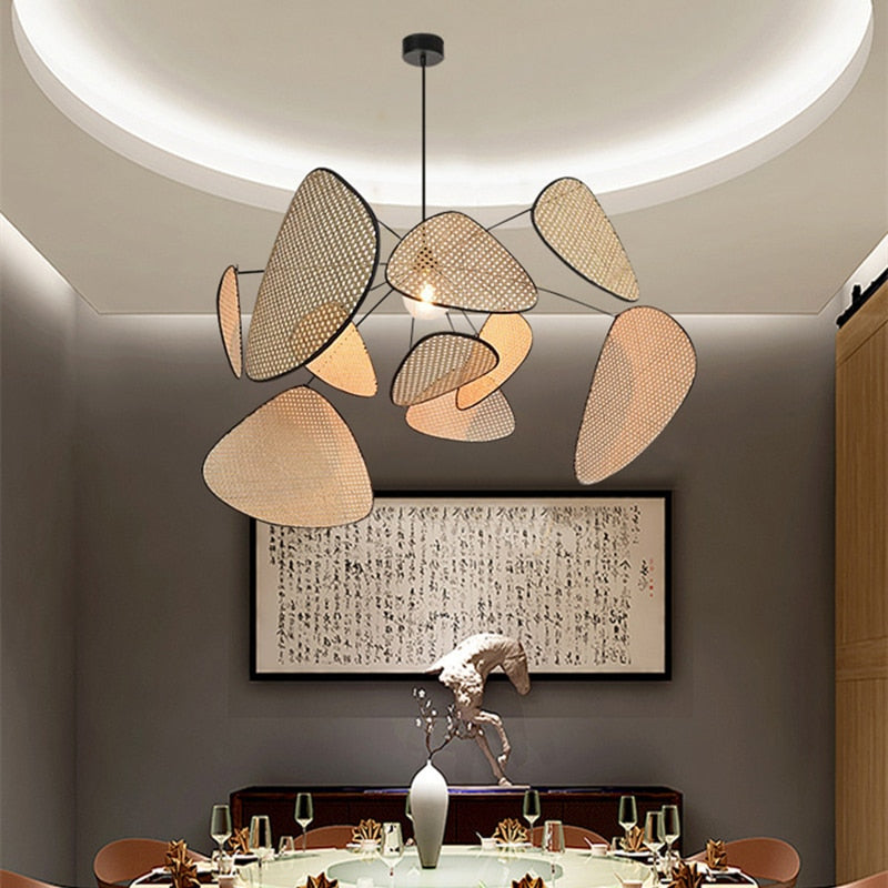 Modern geometric chandelier in rattan with woven bamboo slats – shown in a room setting