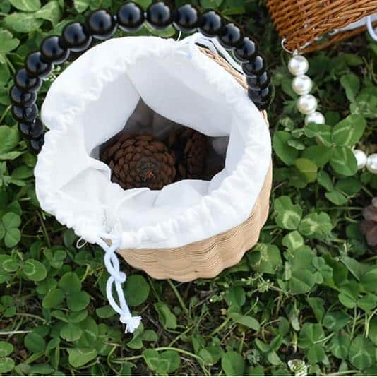 Kids woven storage basket with a beaded handle – shown outdoors (2)