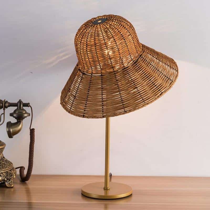Rattan desk lamp with a handwoven hat-shaped shade – shown lit