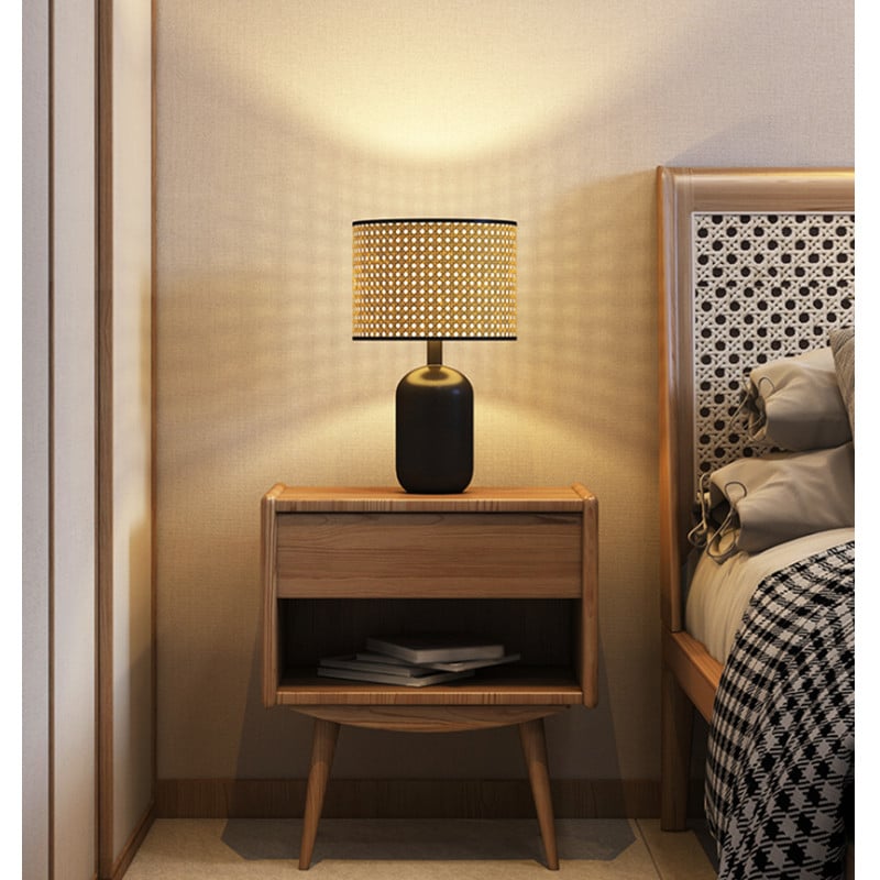 Rattan LED desk lamp with a handwoven shade and black metal base – shown in a room setting (3)