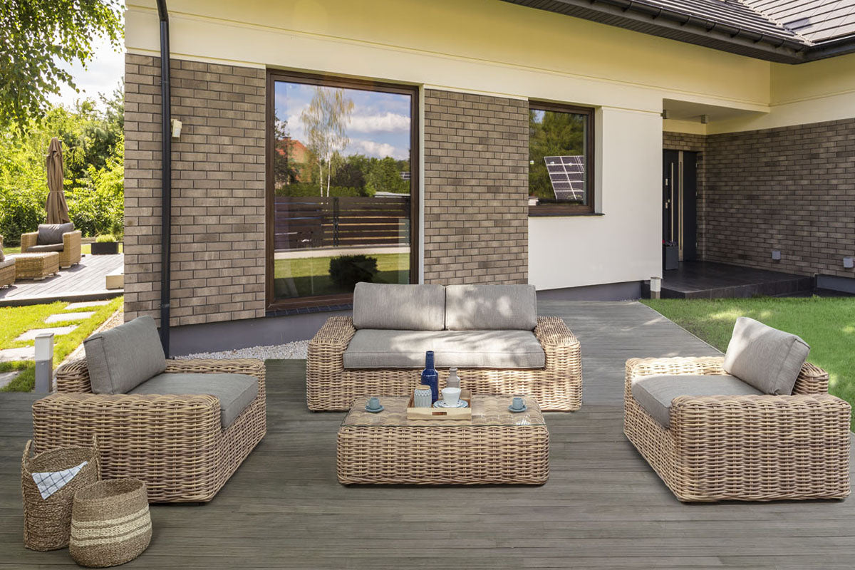 Bali round resin wicker patio set with 3-seat sofa, two armchairs and glass table – shown outdoors (4)