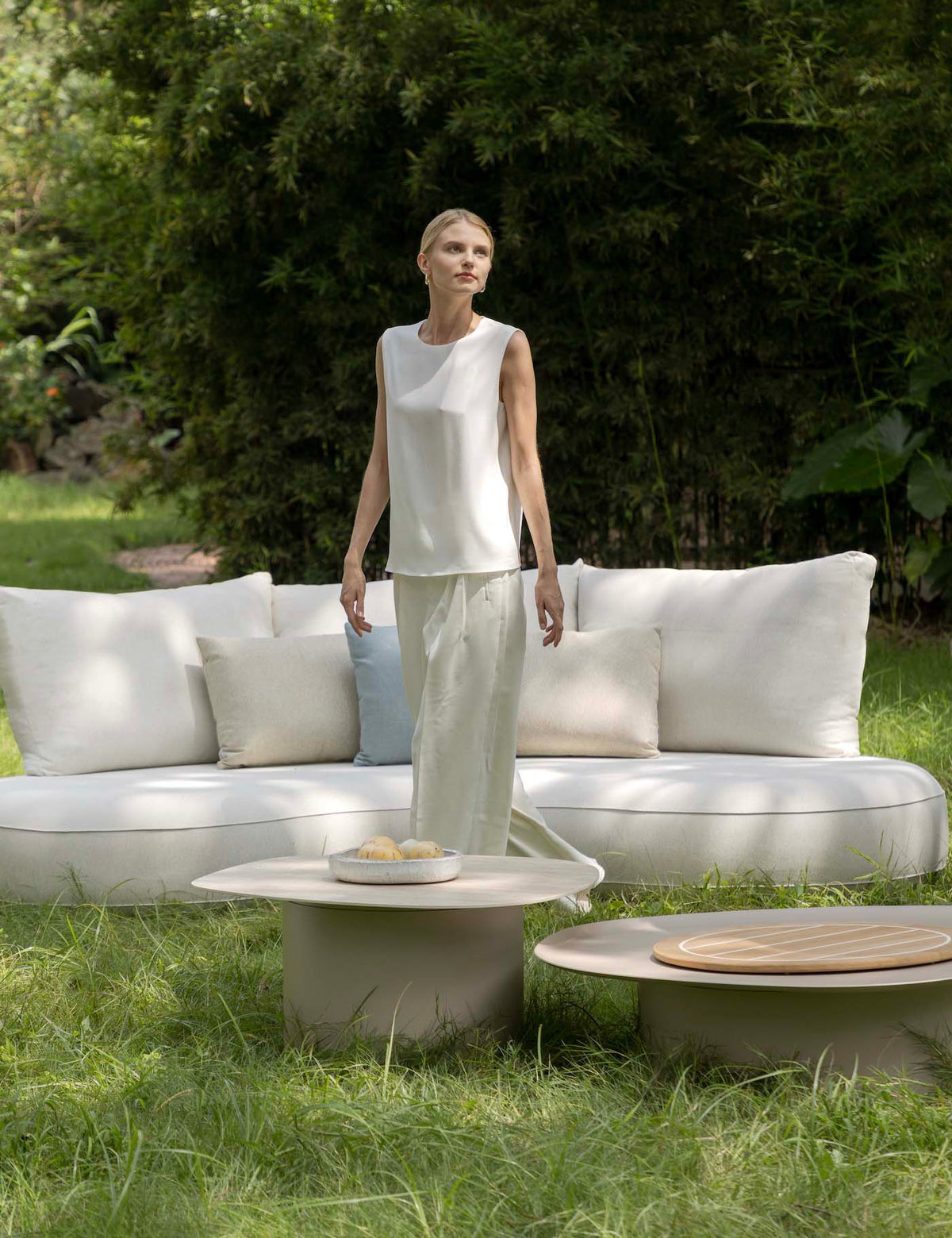 Coffee table from the Elyo 4-seat beige curved aluminum outdoor sofa set – shown outdoors