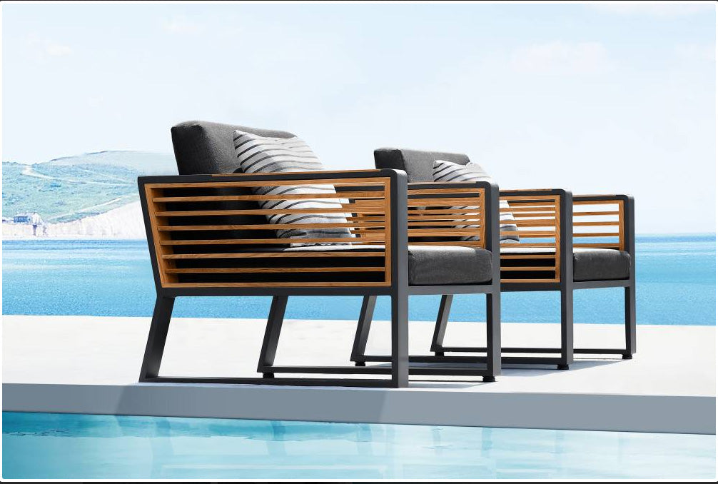 Armchair from the Cofy Bis aluminum patio set with teak and aluminum coffee table with drink cooler – shown outdoors (2)