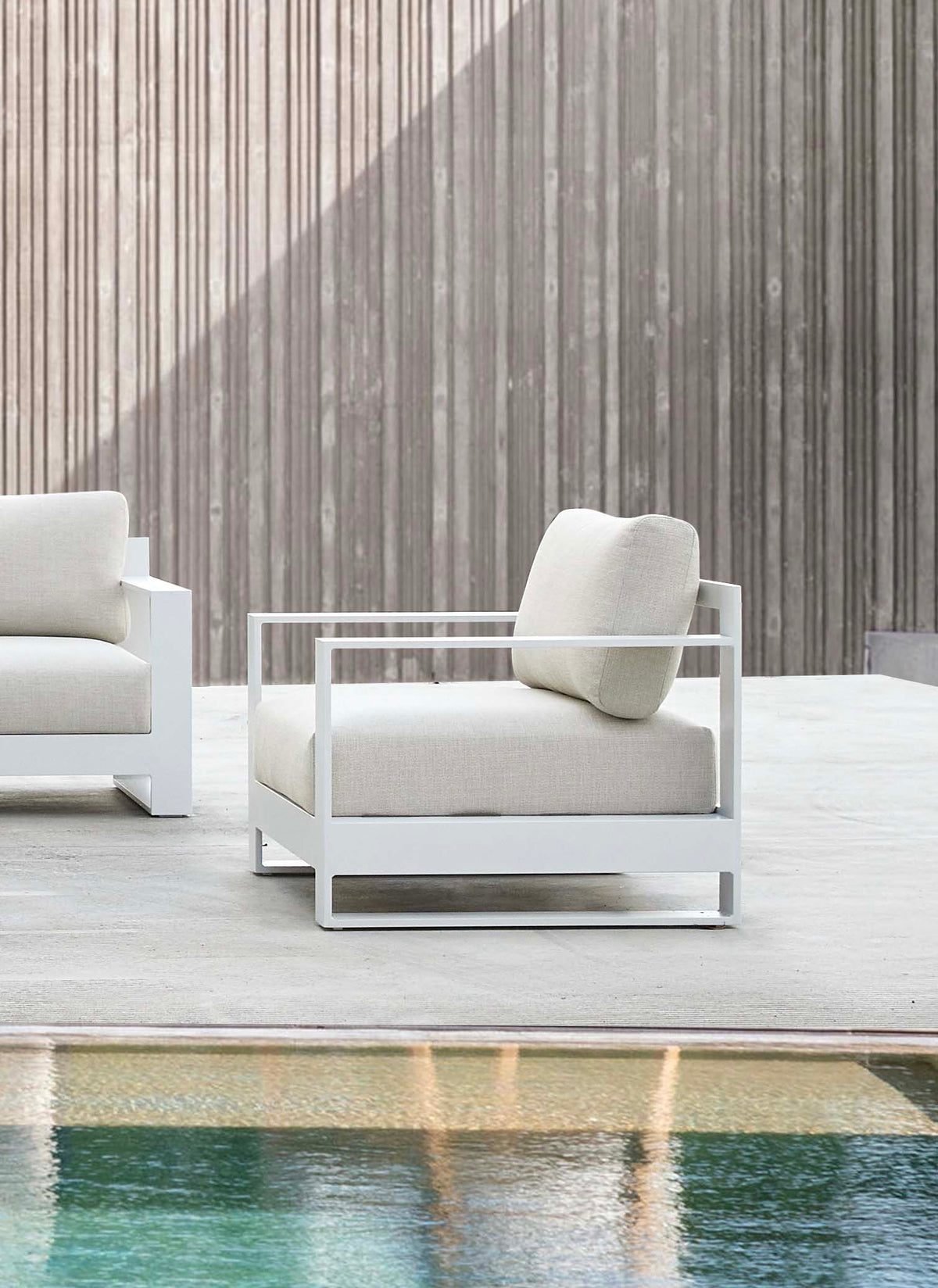 Armchair from the Iris 7-seat white modular aluminum outdoor sectional – shown outdoors