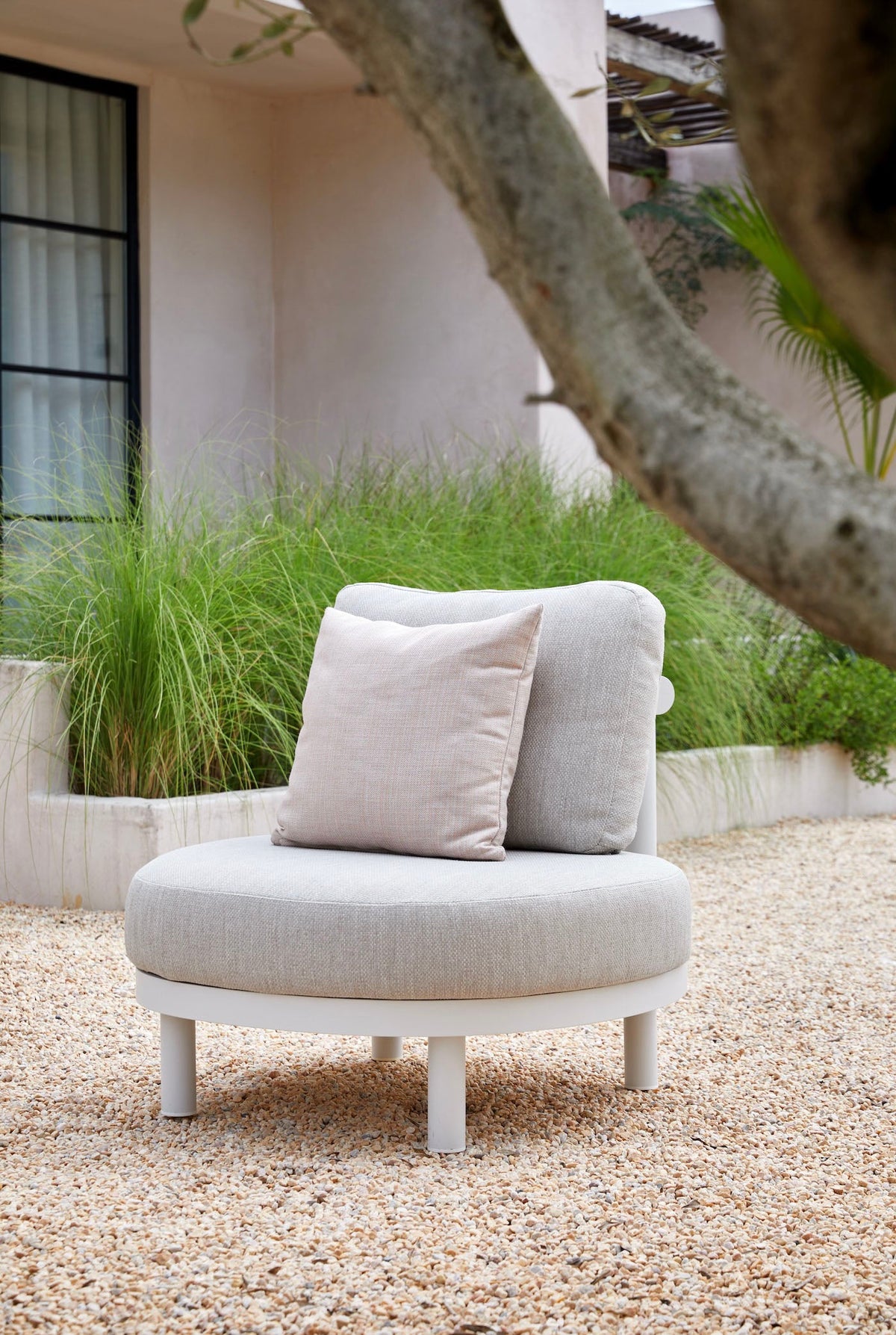 Armchair from the Ambre white aluminum sofa set with light gray cushions – shown outdoors