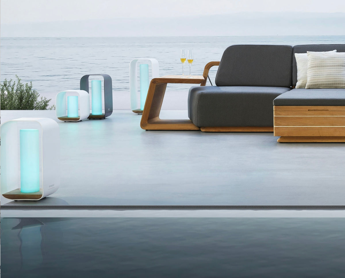 Onda white aluminum and teak cordless outdoor lamp – shown lit outdoors