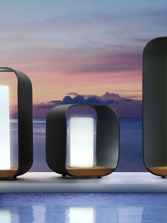 Onda black aluminum and teak cordless outdoor lamp – shown lit outdoors