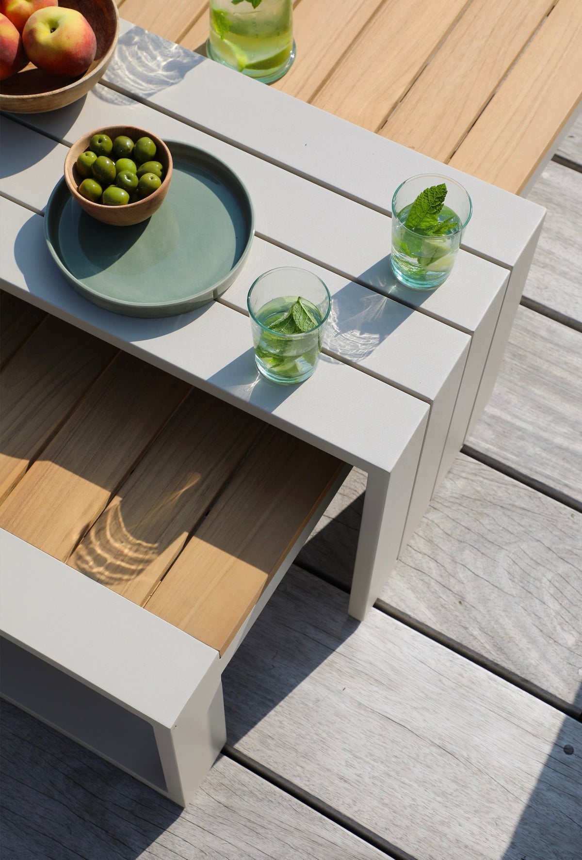 Coffee table from the Mael convertible aluminum outdoor sofa set with adjustable back – shown outdoors