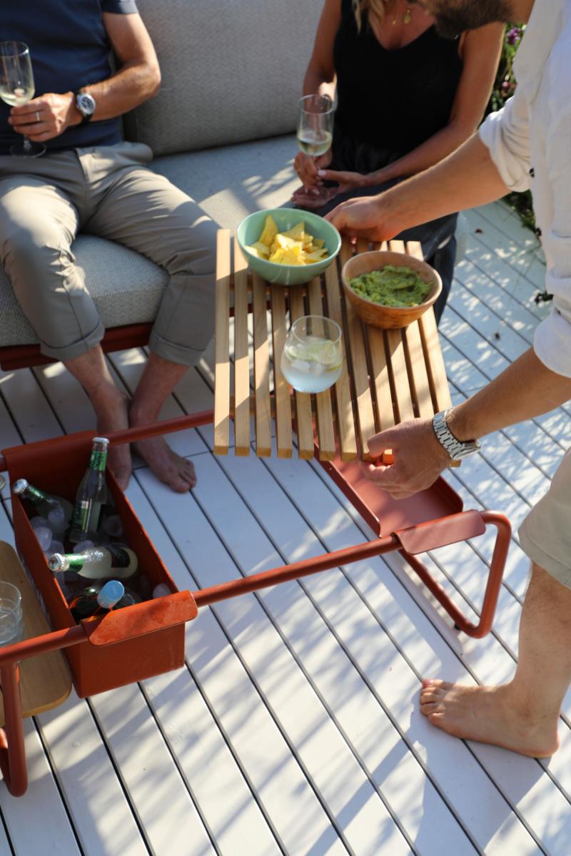 Sunny aluminum coffee table with teak center and drink cooler – shown in use
