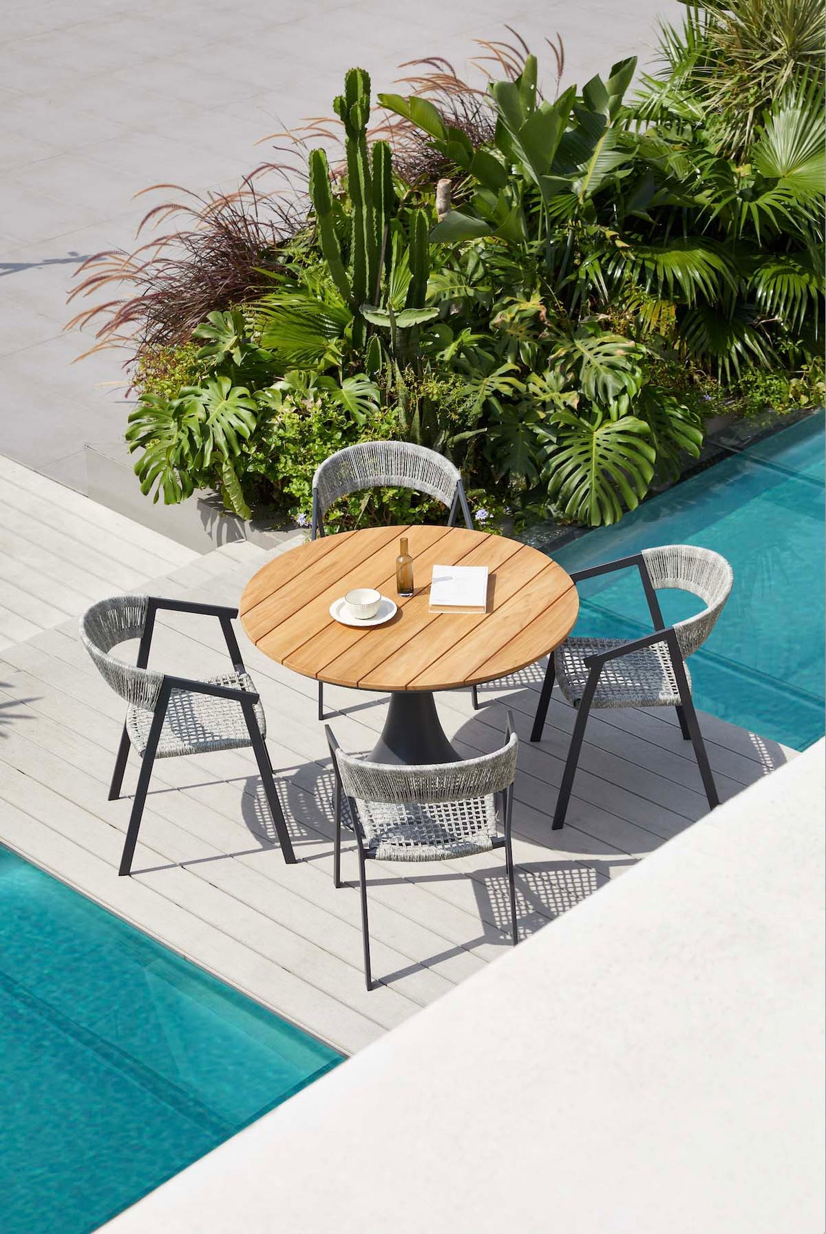 Fano black aluminum round teak-top patio table – shown outdoors (4)