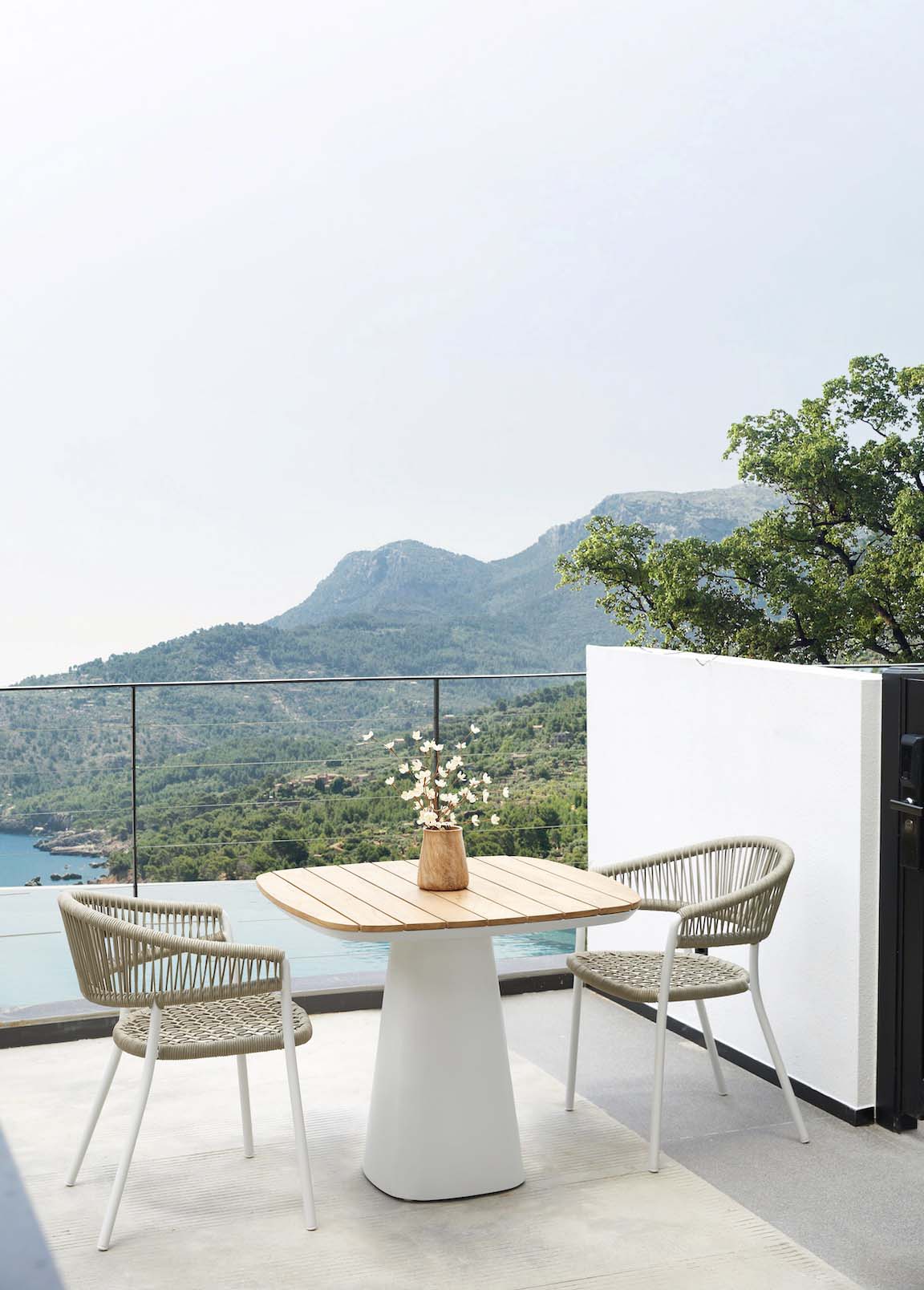 Milo square solid teak top patio table – shown outdoors (4)