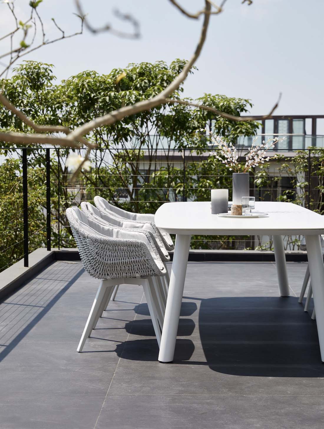 Lara rounded-corner ceramic and white aluminum outdoor dining table – shown outdoors (2)