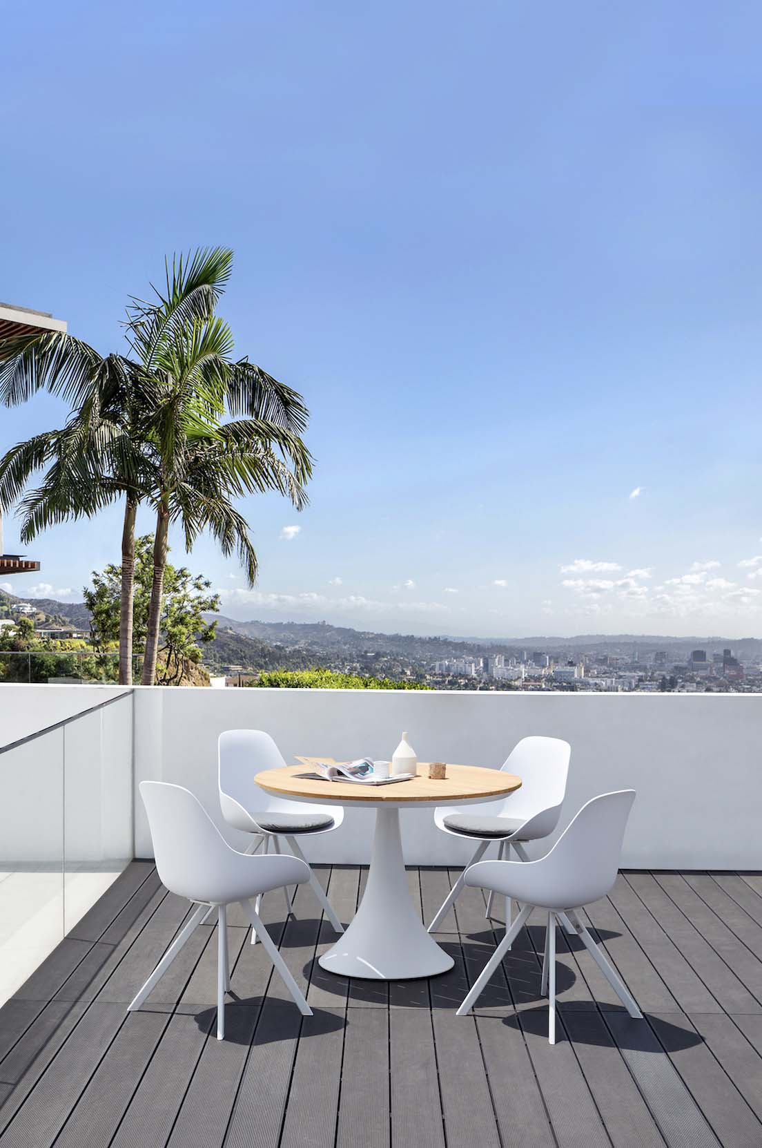 Fano white aluminum round teak-top patio table – shown outdoors (5)
