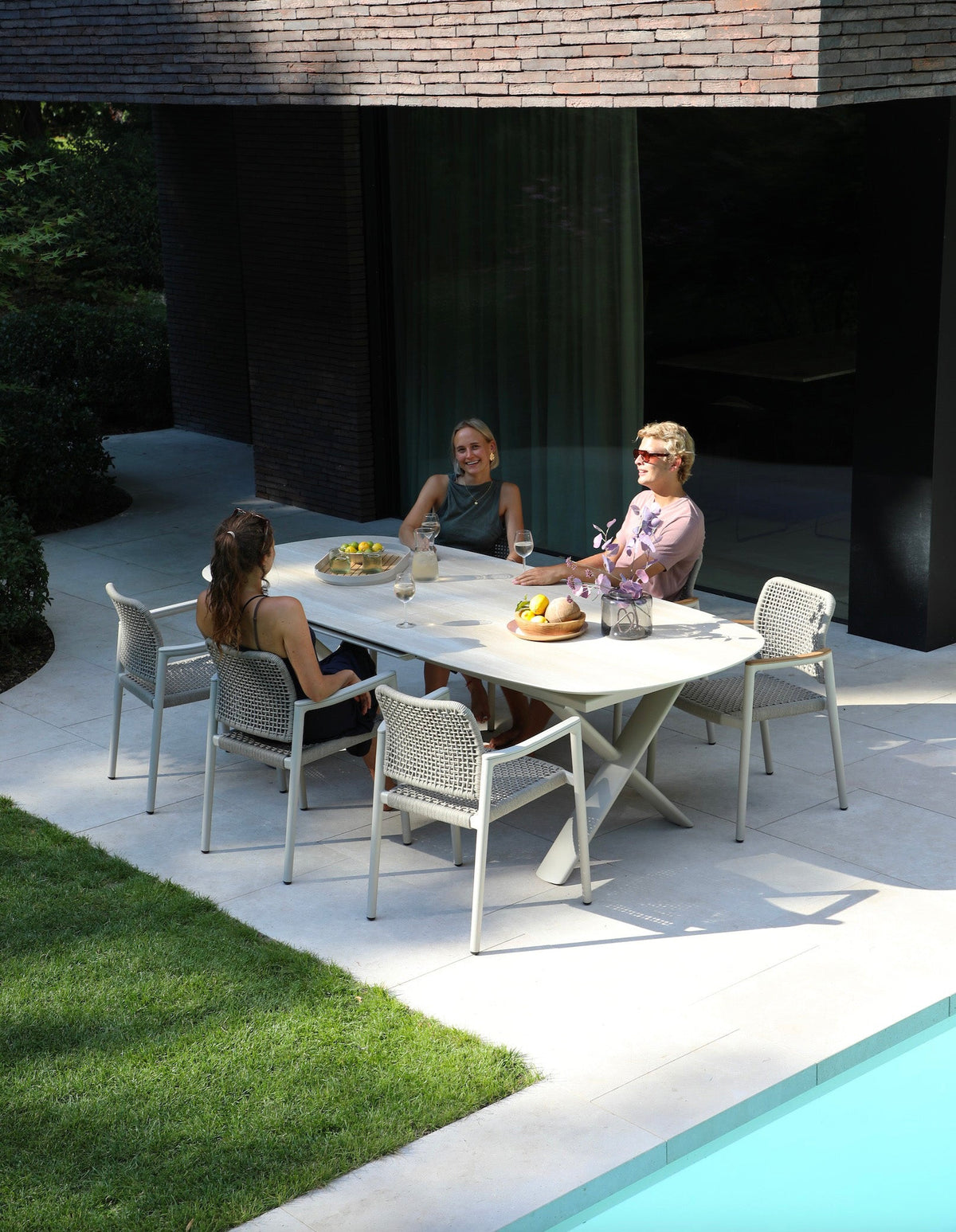 Livio beige oval extendable ceramic outdoor dining table – shown outdoors (5)