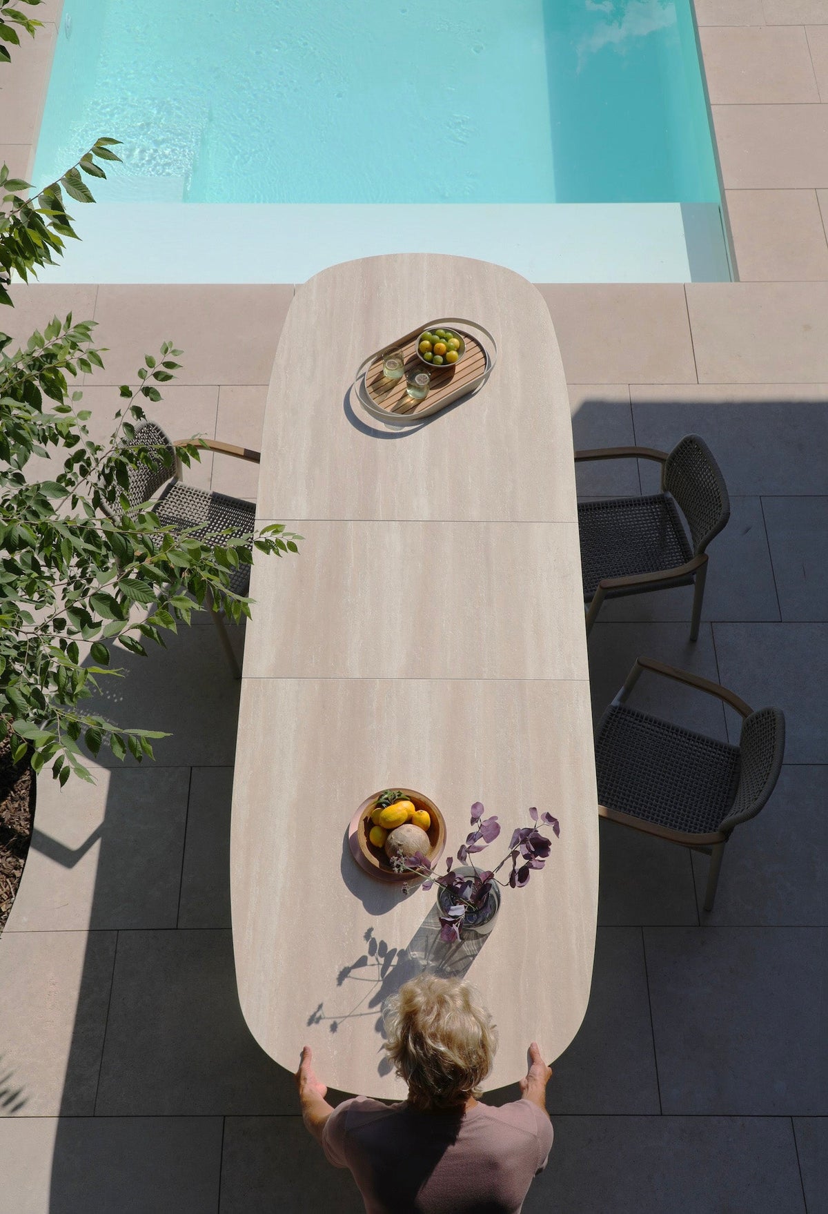 Livio beige oval extendable ceramic outdoor dining table – shown outdoors (2)