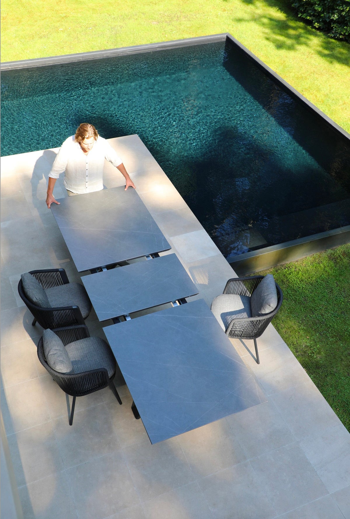 Livio ceramic-top aluminum outdoor dining table with sliding extension – shown outdoors (4)