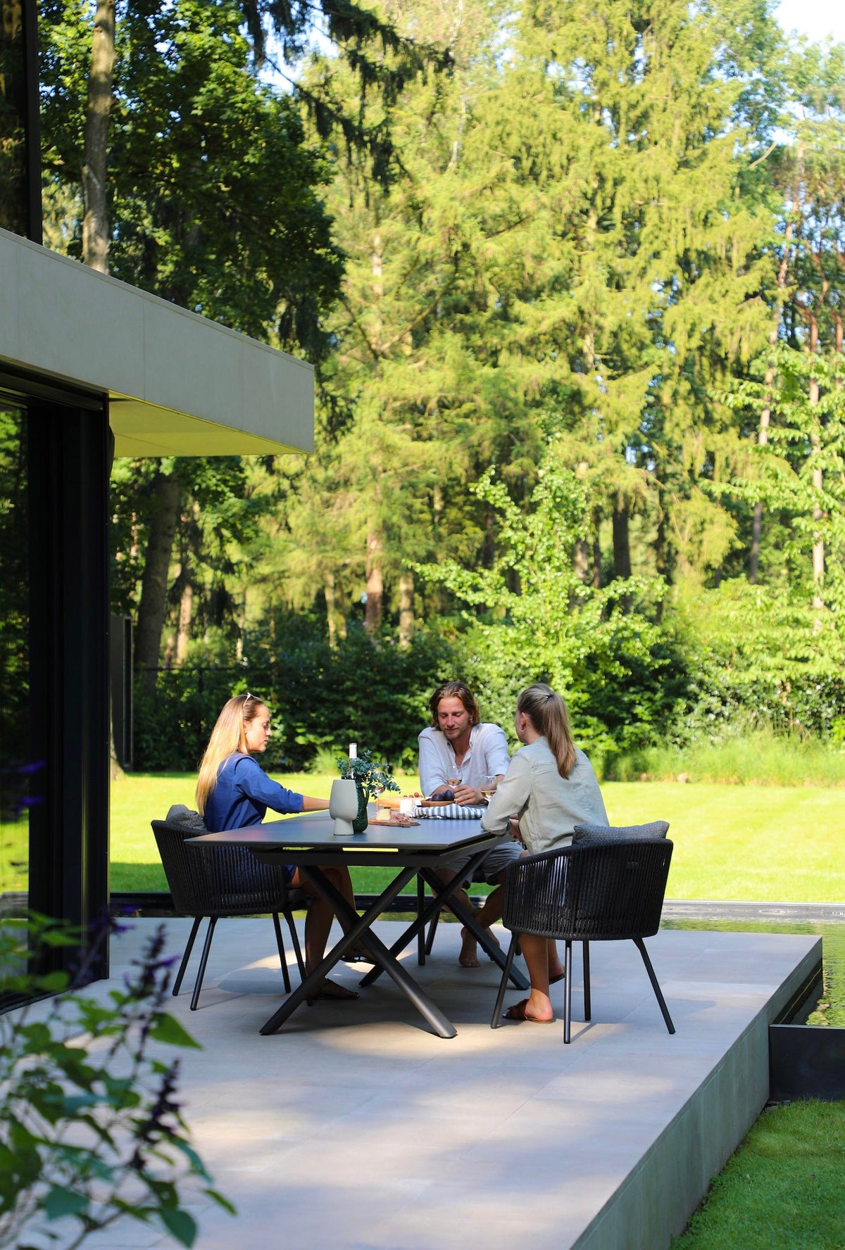 Livio ceramic-top aluminum outdoor dining table with sliding extension – shown outdoors (6)
