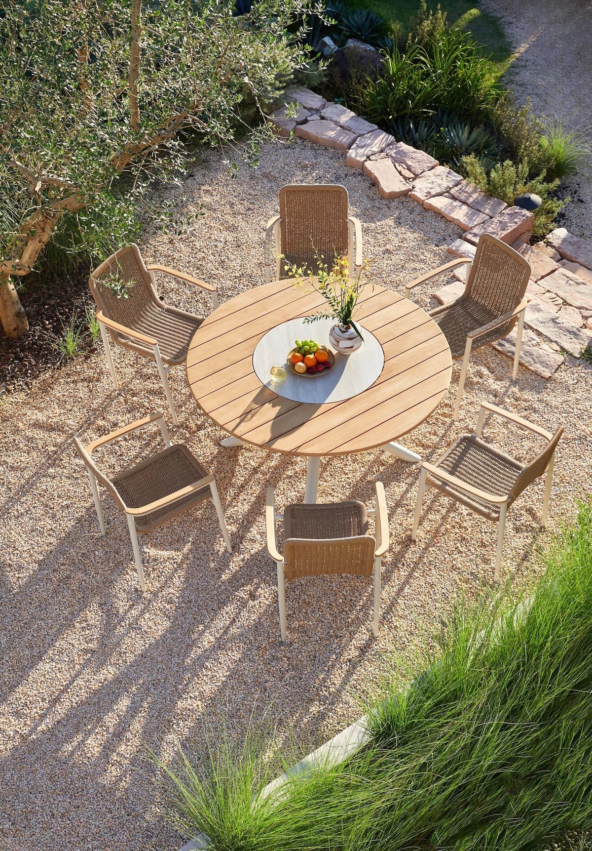 Ariel round teak outdoor dining table with rotating ceramic center – shown outdoors (4)