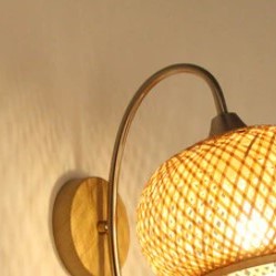 Handwoven rattan ball wall sconce – shown lit (2)