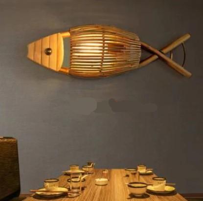Handwoven natural rattan fish-shaped wall sconce – shown lit