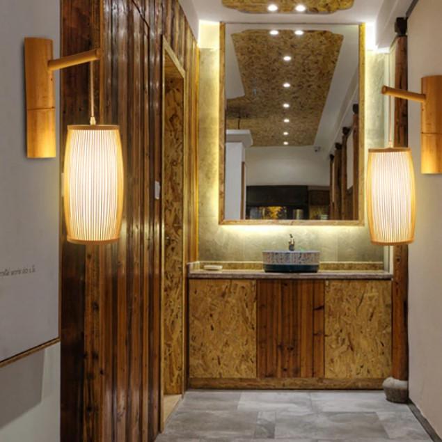 Domed rectangular handmade rattan wall sconce – shown lit in a room setting