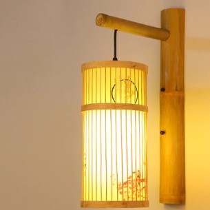 Cylindrical rattan wall sconce with an Asian-inspired woven pattern – shown lit