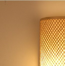 Framed rectangular handwoven rattan wall light – close-up detail, lit