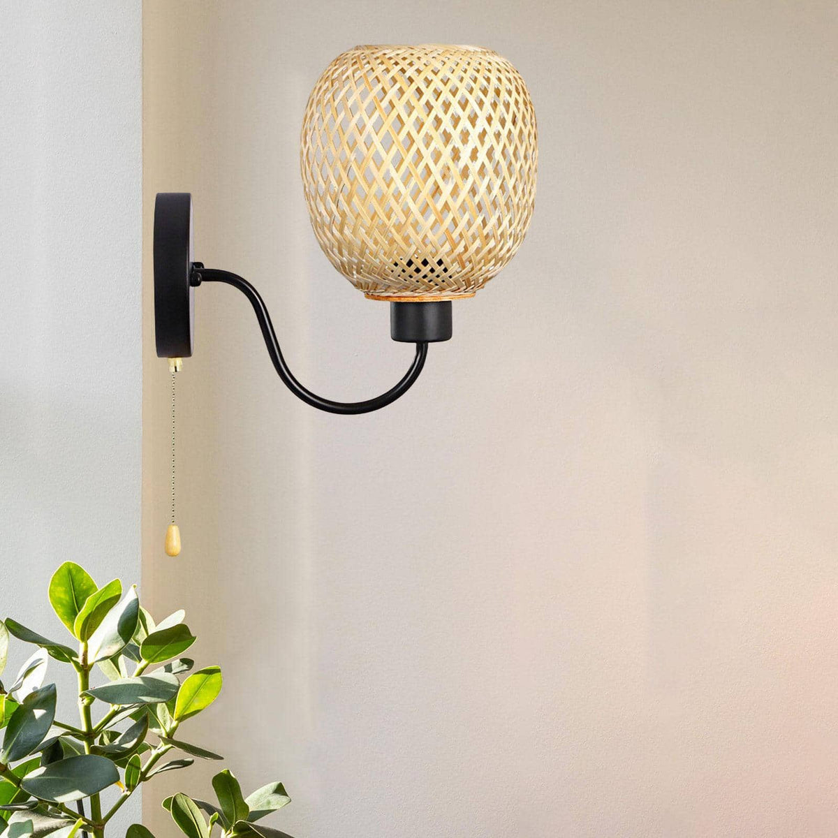 Retro wall sconce with a handwoven bamboo shade and matte black iron arm – shown lit