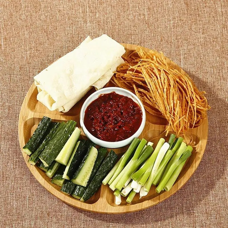 Round handwoven bamboo plate divided into compartments – shown in a room setting