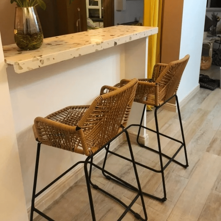 Scandinavian rattan bar stool with a hand-braided seat – shown in a room setting