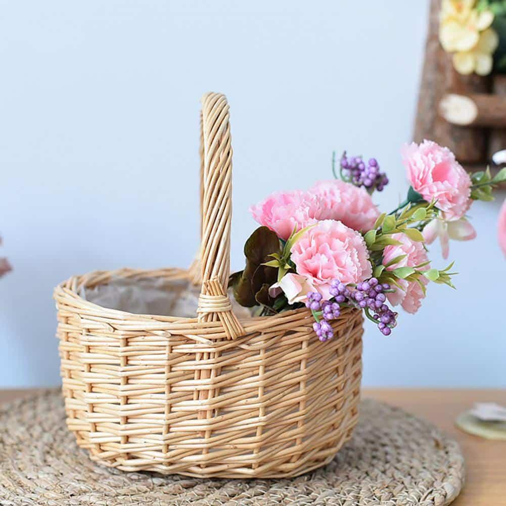 Beige round handwoven rattan basket with a sturdy handle – shown in a room setting (2)