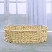 Light hand-braided rattan moses basket – shown in a room setting