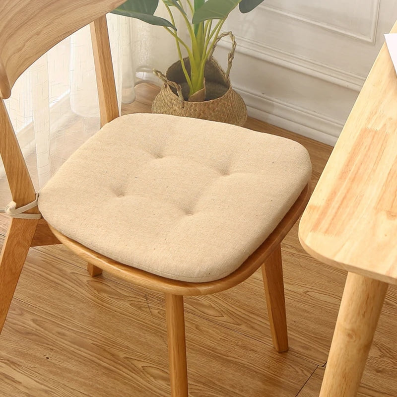Beige cotton chair cushion for a rounded rattan seat – shown in a room setting (2)