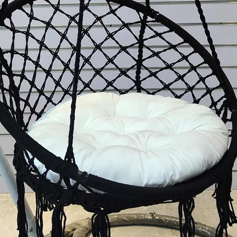 Modern round cotton-filled cushion for a rattan loveseat – shown in a room setting