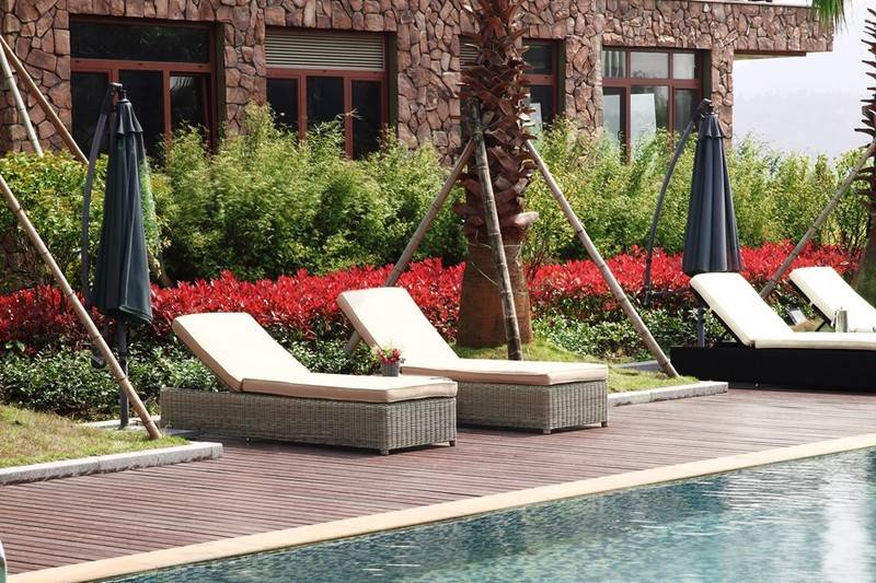 Dune round resin wicker chaise lounge set of two with wheels – shown outdoors (4)