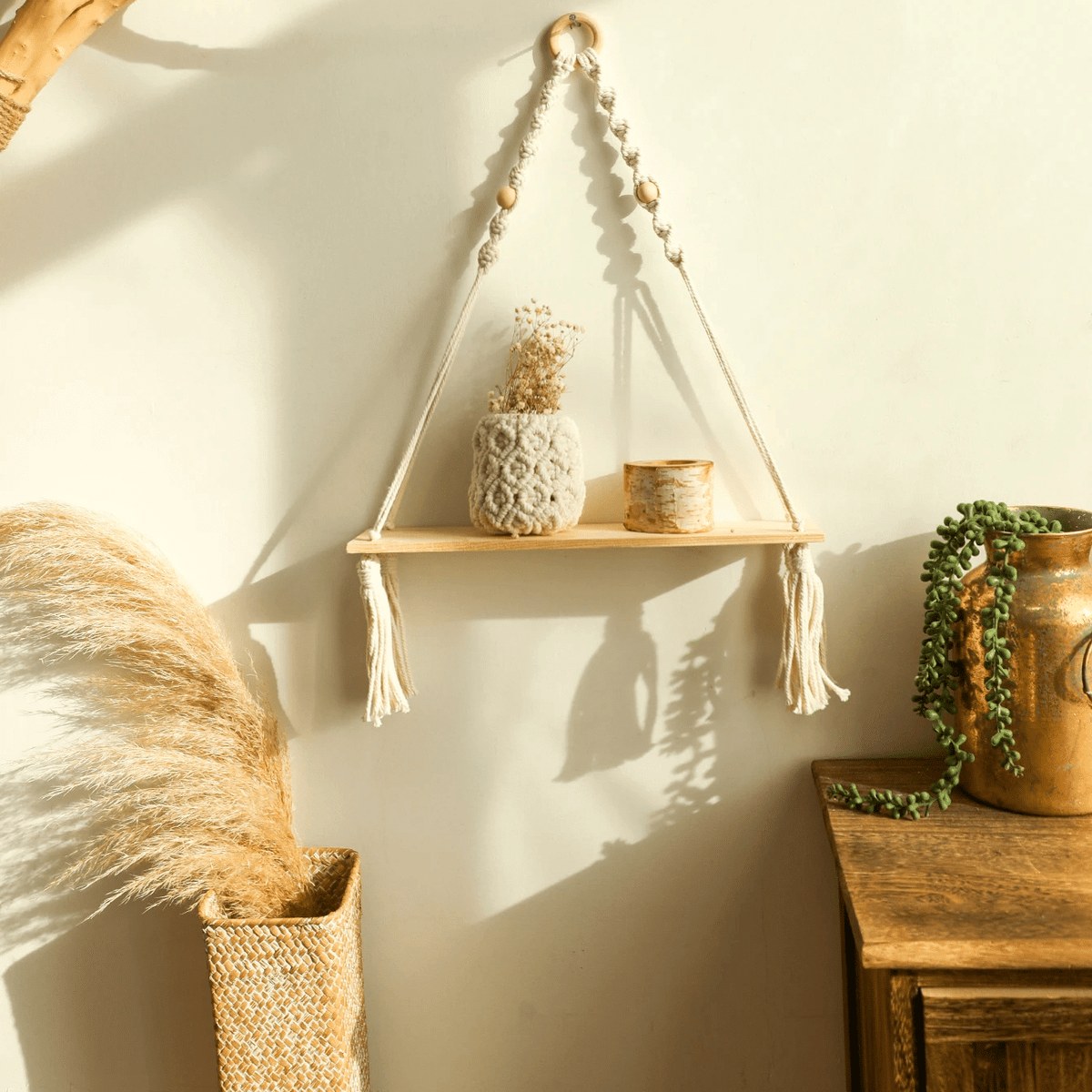 Boho hanging wood shelf suspended by hand-knotted macramé – shown in a room setting
