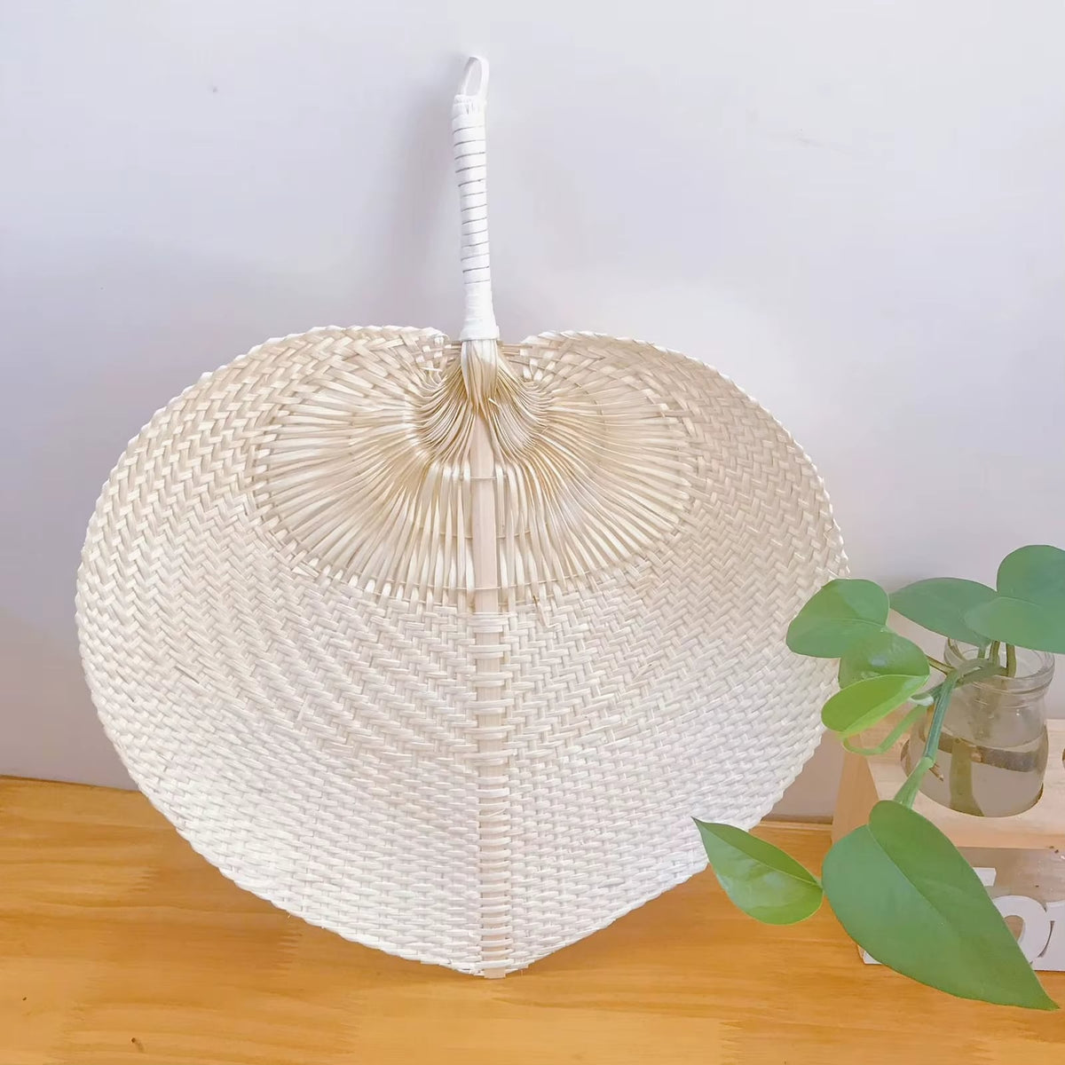 Handcrafted natural rattan fan wall decor – shown in a room setting
