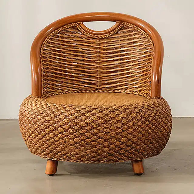 Small low brown rattan armchair with rounded shapes
