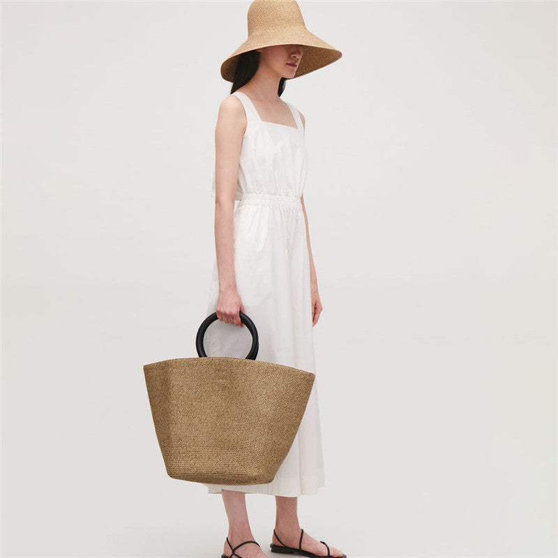 Large oval rattan handbag with a leather handle and bamboo clasp – worn by a model (2)