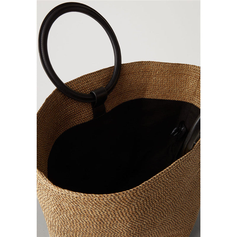 Large oval rattan handbag with a leather handle and bamboo clasp – close-up detail