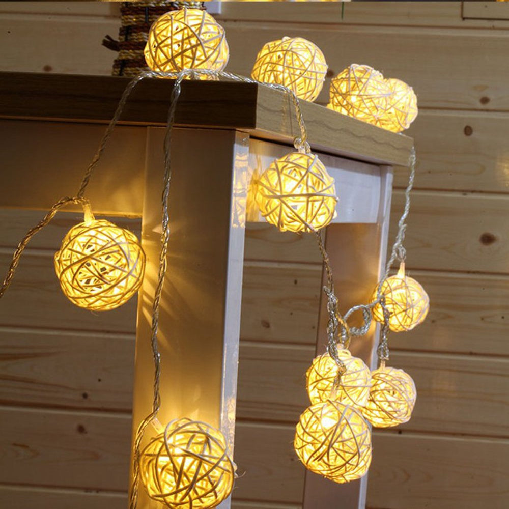 Rattan Christmas string lights with miniature woven shades – shown lit in a room setting