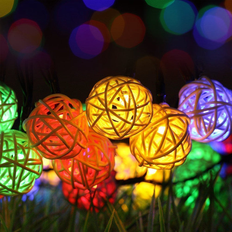 Rattan Christmas string lights with miniature woven shades – multicolor variant, shown lit in a room setting