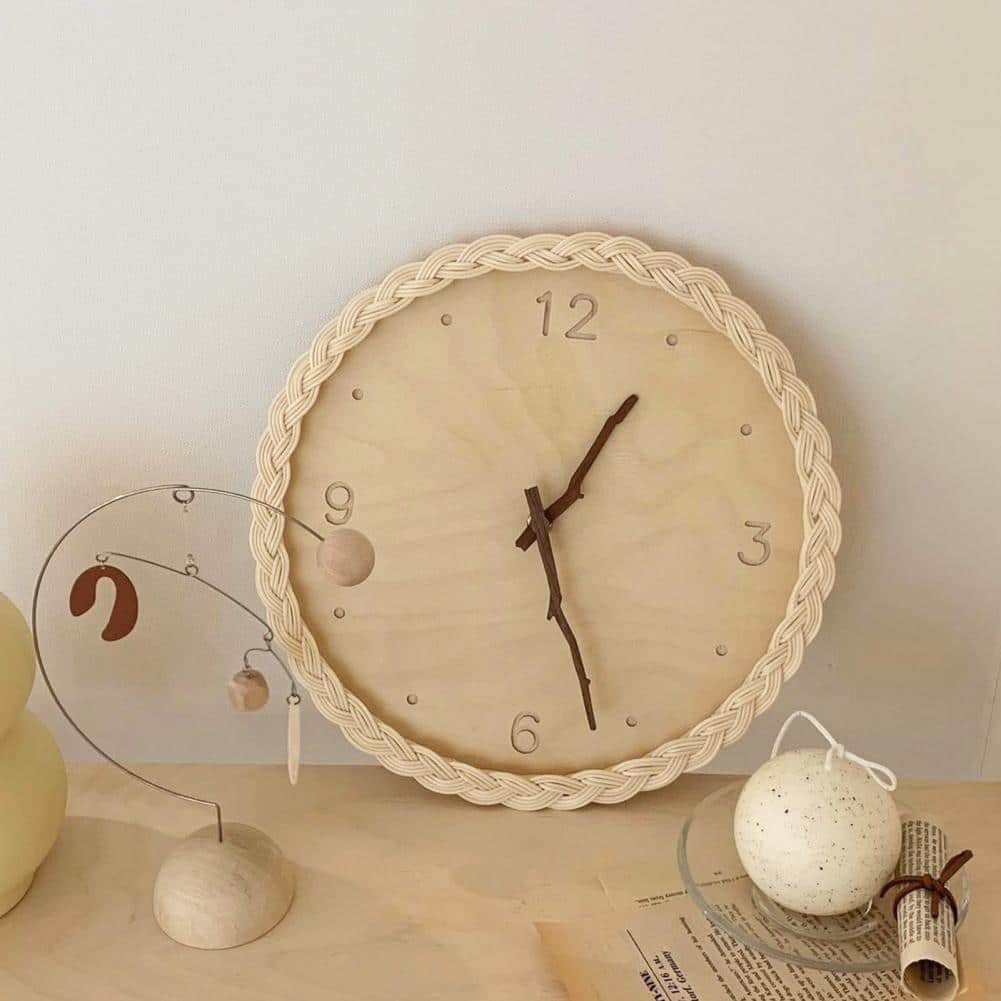 Round braided rattan wall clock with branch-shaped hands – shown in a room setting (2)