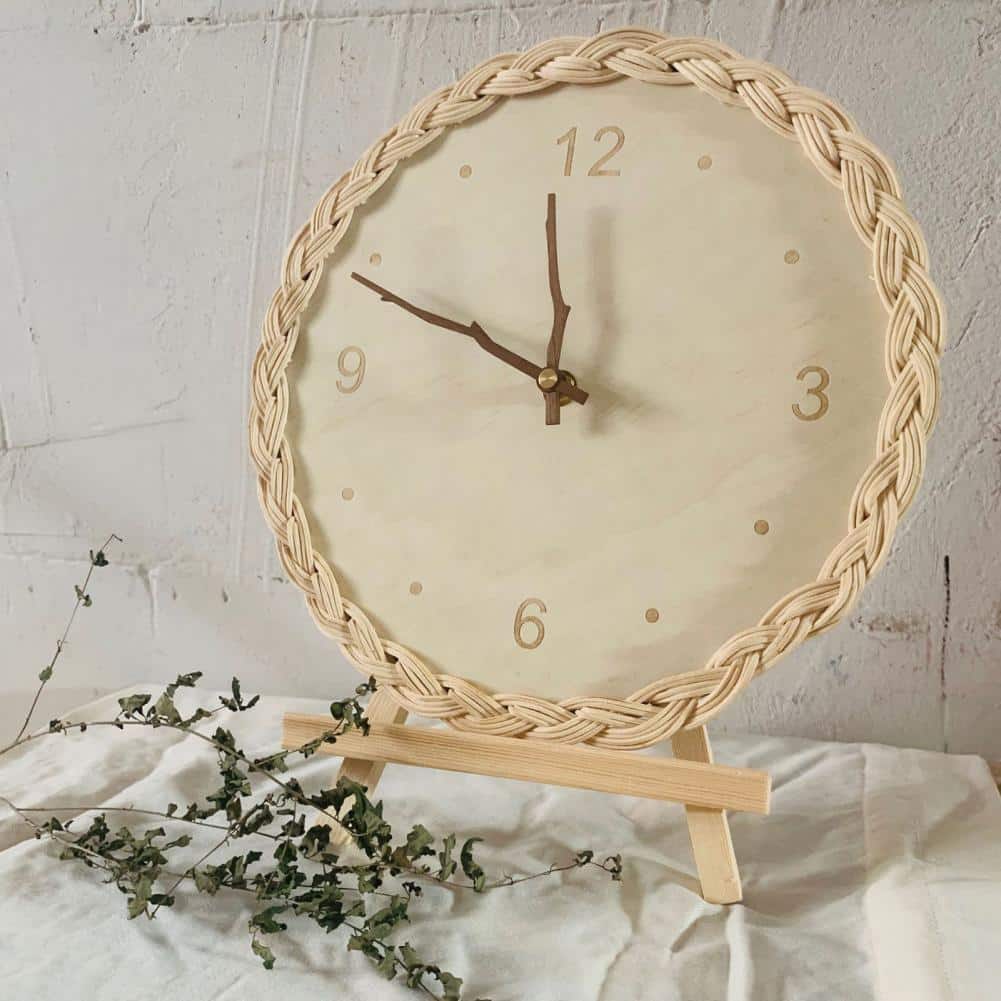 Round braided rattan wall clock with branch-shaped hands – shown in a room setting (4)