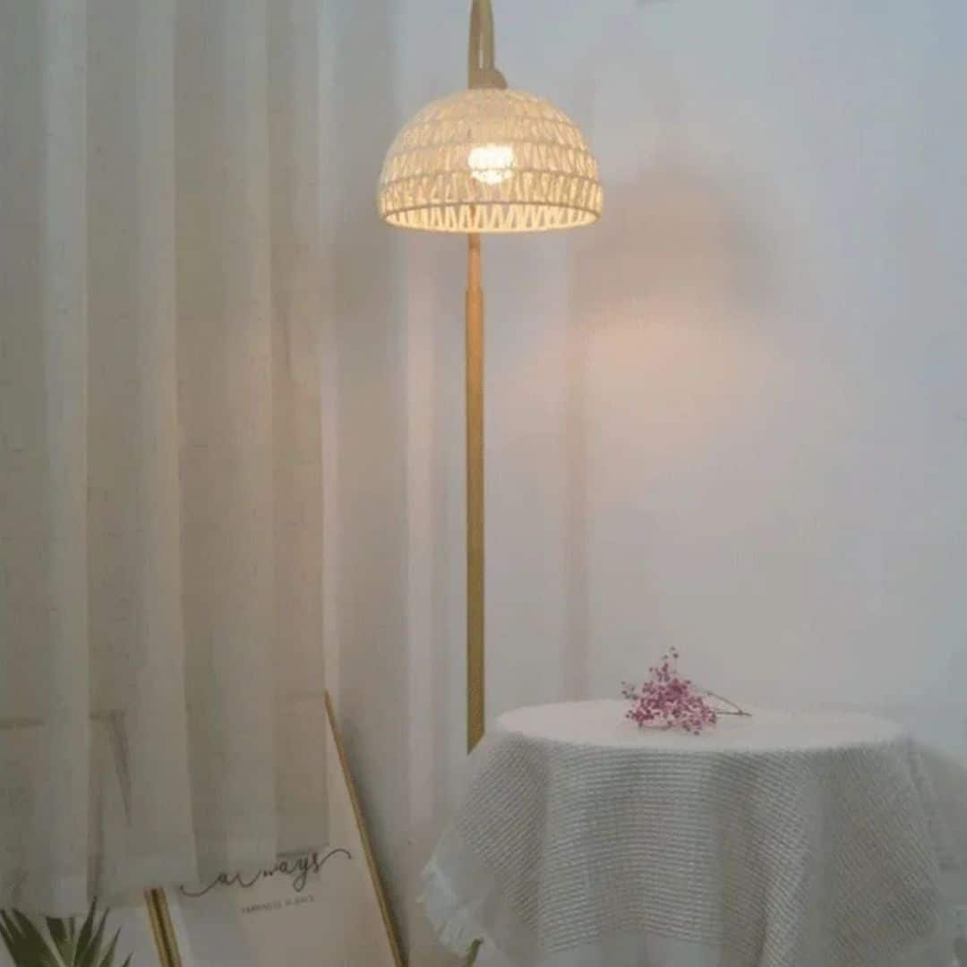 Minimalist rattan floor lamp with a slender stem and woven shade – shown in a room setting