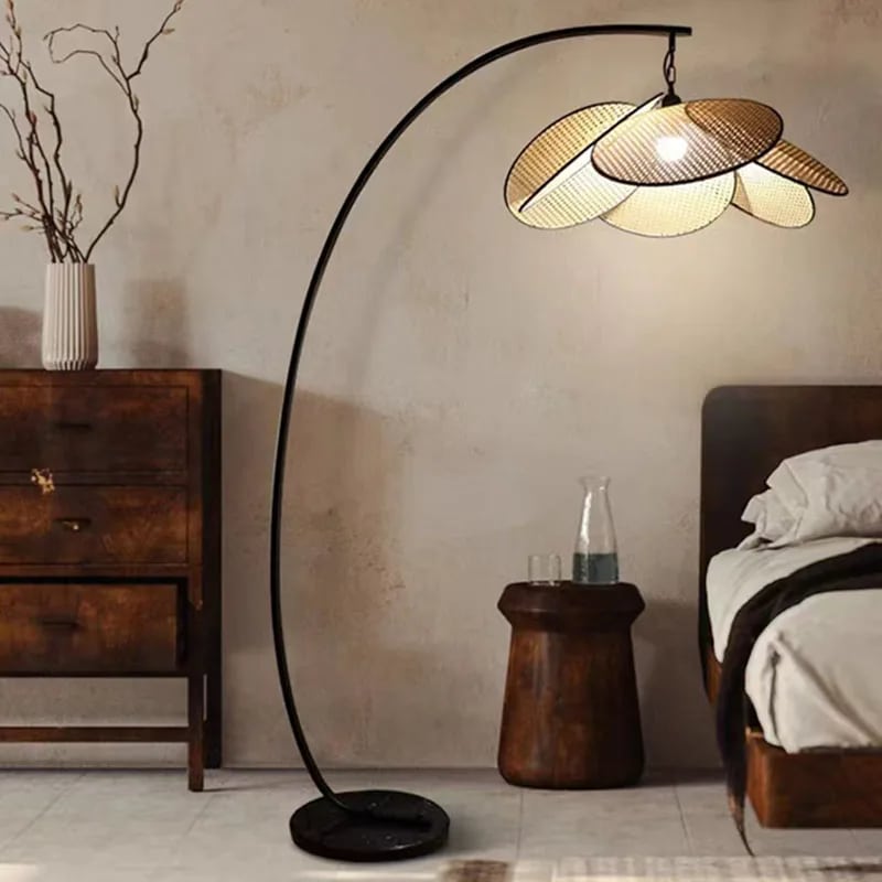 Rattan petal LED floor lamp with petals arranged in a crown – shown lit in a room setting