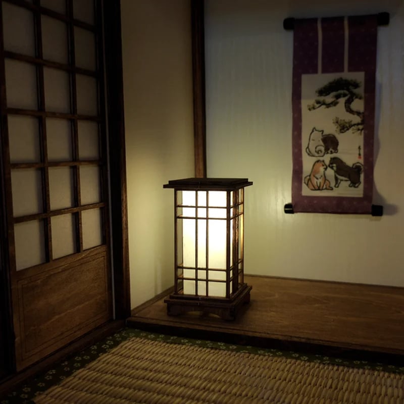 Japanese lantern-style light wood LED bedside lamp with slats – shown lit in a room setting (2)