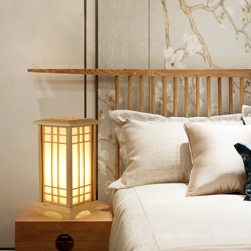 Japanese lantern-style light wood LED bedside lamp with slats – shown lit in a room setting