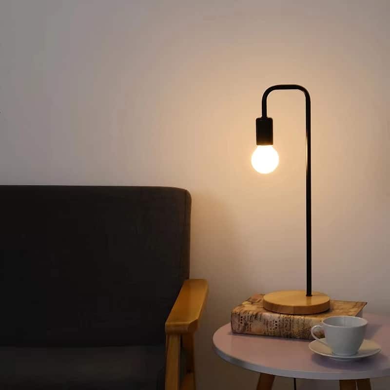 Vintage hand-turned wood and wrought iron LED bedside lamp – shown lit in a room setting