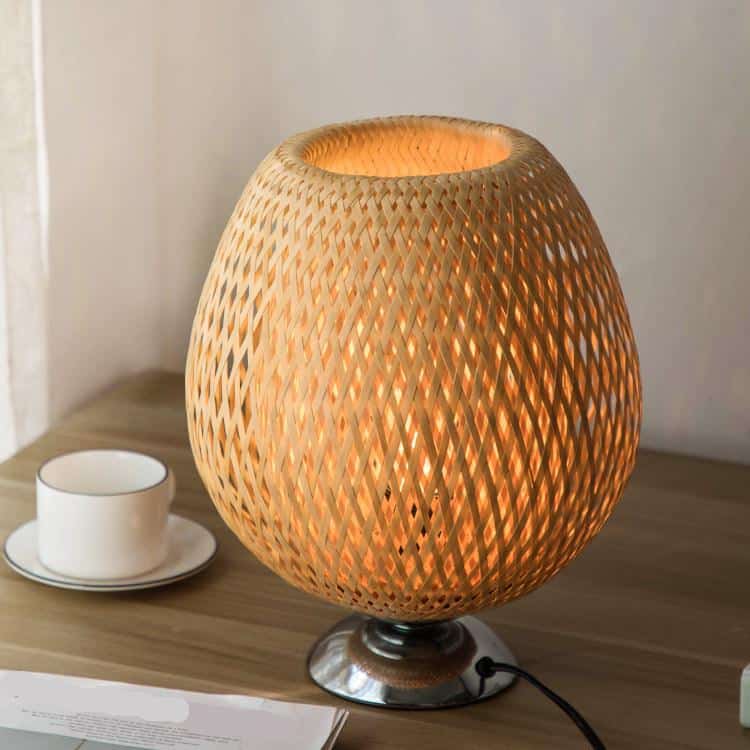 Round handwoven rattan table lamp on a metal base